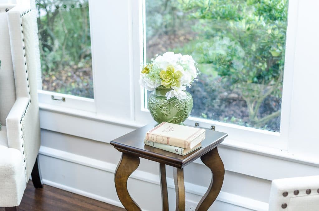 Vase with flowers and two stacked books on a small end table