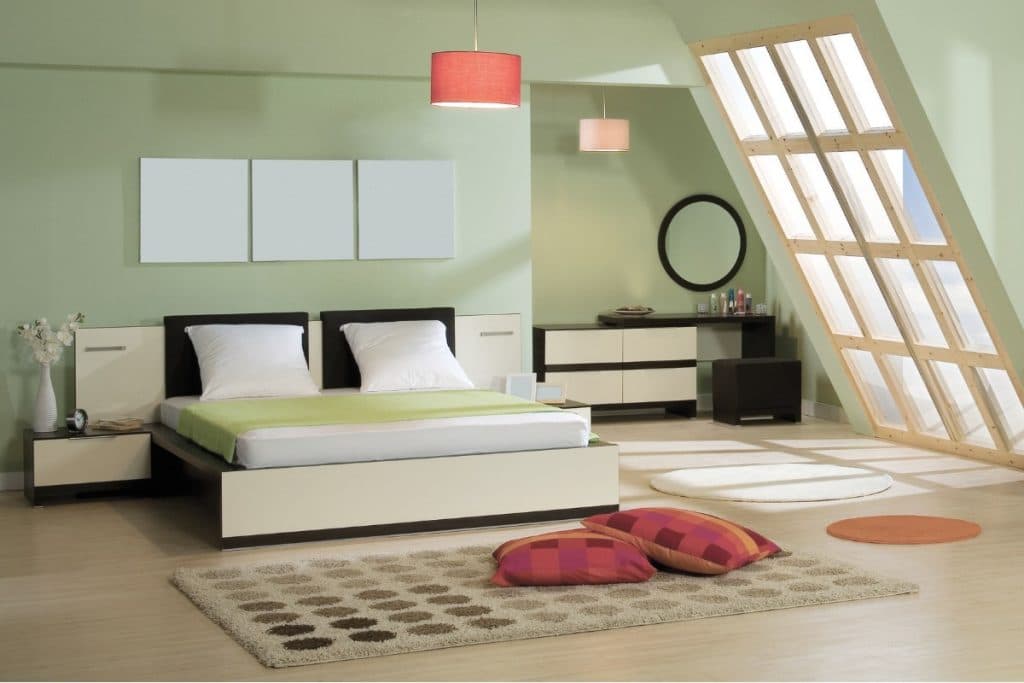 Light green bedroom with red light fixture and red accent pillows