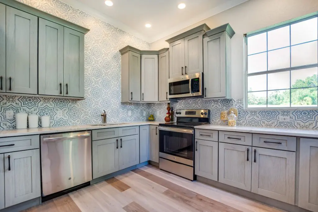Kitchen with beautiful blue patterned tile staged by MHM Professional Staging for Zombie House Flipping season three episode one.
