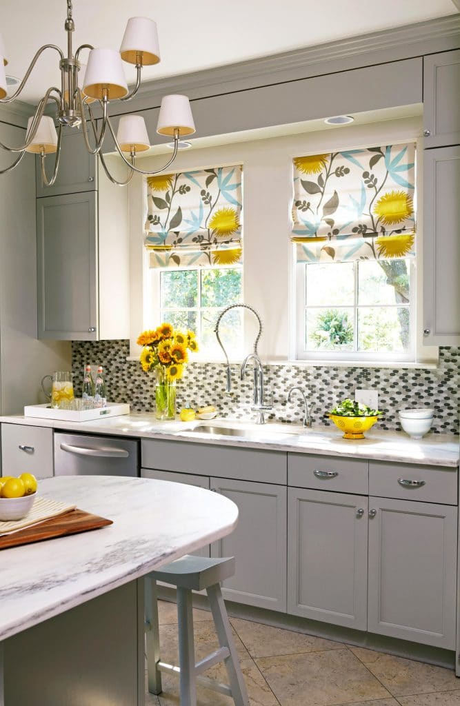A kitchen with gray countertops and splashes of yellow.