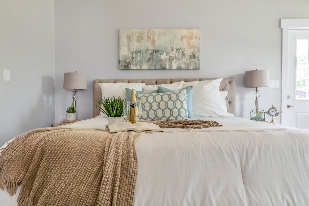 A bedroom staged with neutral bedding.
