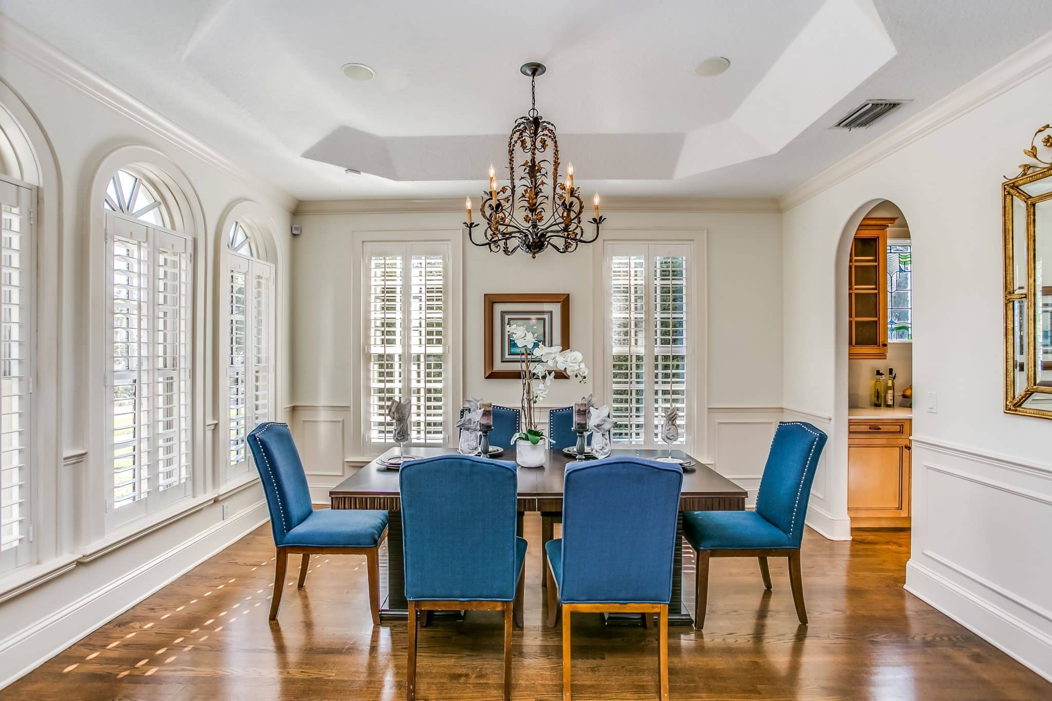 A dining room with blue fabric chairs around the table.