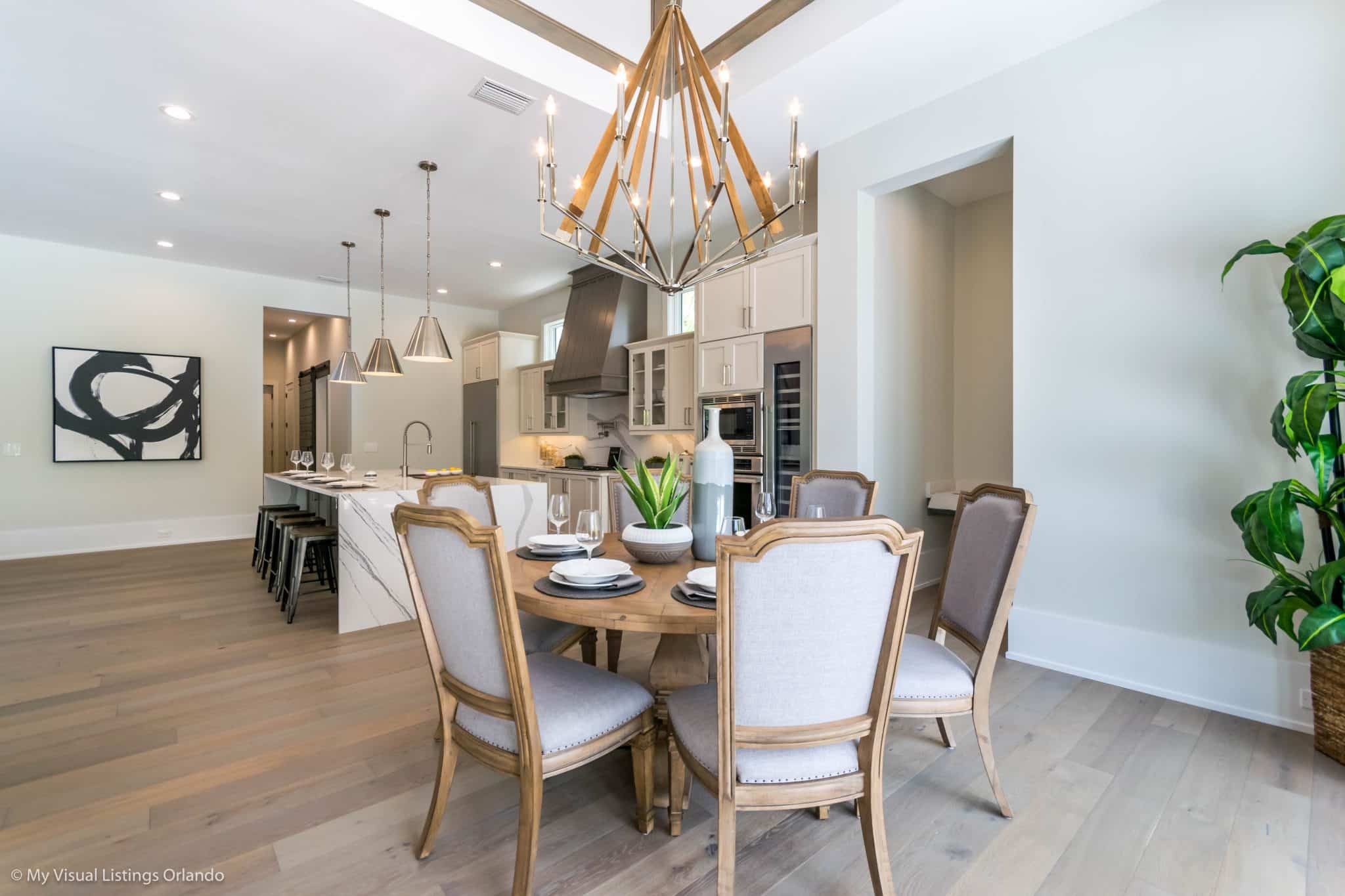 A dining room with a modern lighting fixture centered over the table.